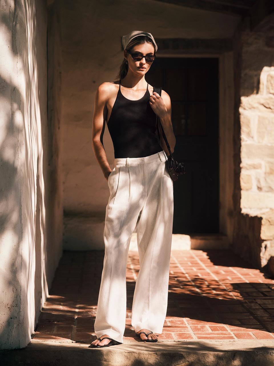 Model posing in white linen pants